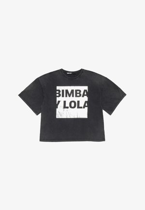 Črna skrajšana majica iz bombaža, ki ima velik bel pravokotnik s slikovno grafiko, na katerem je v krepki pisavi napisan tekst "BIMBA Y LOLA". Kratke rokave.