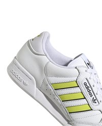 Fehér bőr sportcipő sárga részletekkel, három csíkkal, perforált elemekkel és párnázott nyakkal. Látható Adidas logó.