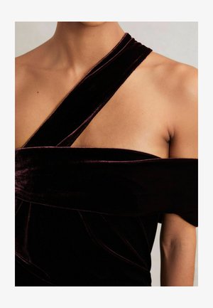 Burgundy velvet dress featuring a twisted shoulder strap design and smooth texture, with draped accents highlighting the bodice.