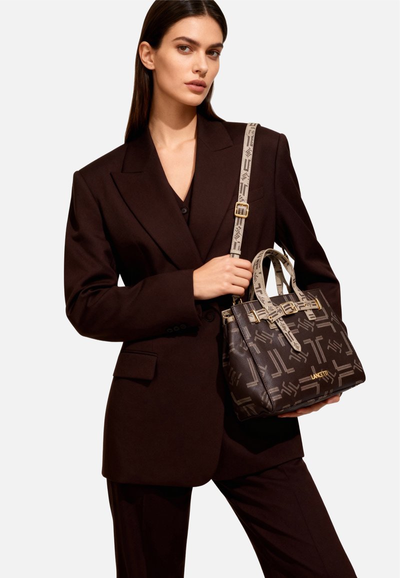 Borsa a tracolla in pelle marrone con motivo geometrico, ferrature dorate e doppio manico. Include una tracolla a contrasto con dettagli con logo.