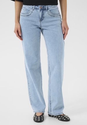 Ljusblå, raka denimjeans med framfickor och kontrasterande sömmar. Bärs med svarta platta skor som har silvernitar.