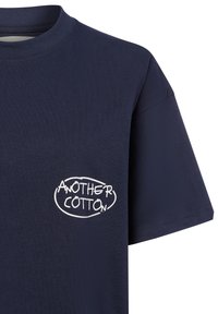 Jūras zila kokvilnas T-kreklis ar apaļu kakla izgriezumu un īsām piedurknēm, ar baltu grafisko tekstu "ANOTHER COTTON" kreisajā krūtī.