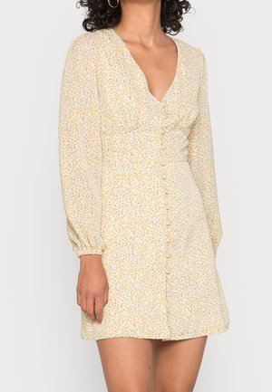 Gelbes Blumenmuster-Kleid mit langen Puffärmeln, V-Ausschnitt und Knopfleiste vorne. Es weist dezente blaue und grüne Blumenmuster auf leichtem Stoff auf.