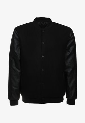 Melnas lidmašīnas tipa jakas ar vilnas korpusu, ādas piedurknēm, ribotu aproču un pogu aizdari. Gluda tekstūra ar elegantu, mūsdienīgu dizainu.