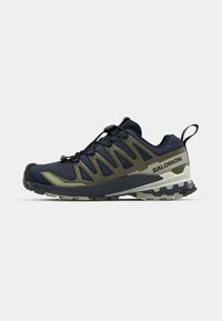 Navy and olive green trail running shoes with mesh upper, thick rubber sole, and quick-lace system; features logo on the side and heel tab.