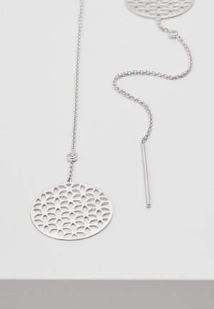 Silver threader earrings with round, openwork floral pattern pendants on a fine chain against a white background.