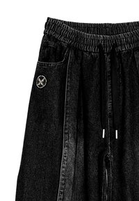 Joggers de mezclilla negra con cintura elástica, cordones, bolsillos laterales y un parche de logo circular en el bolsillo frontal.