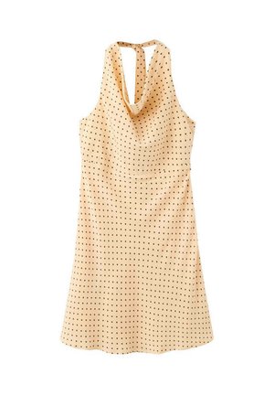 Robe beige sans manches à pois noirs, col halter et détail drapé au dos, suspendue sur un fond blanc.