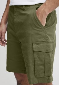 Shorts cargo vert olive avec poches latérales, en mélange de coton, dotés de coutures renforcées et d'une coupe décontractée pour le confort.