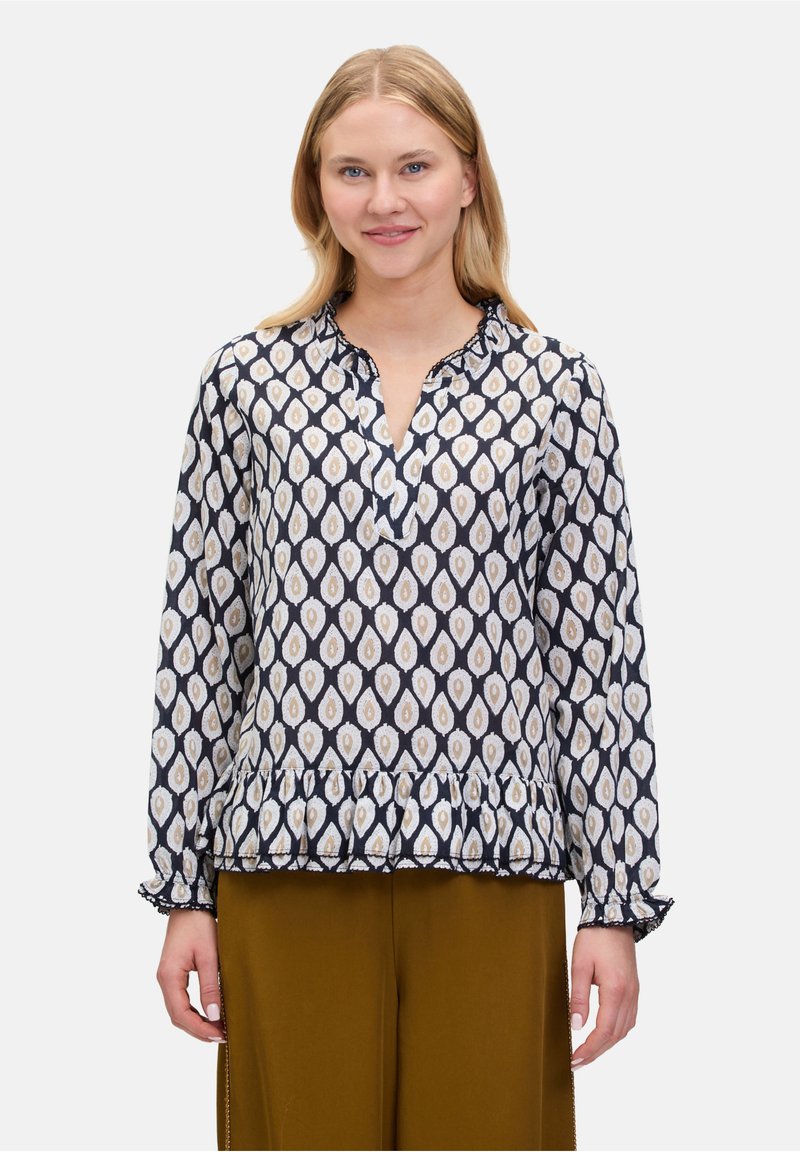 Bluzka w granatowy wzór z dekoltem w serek i falbaniastymi mankietami. Posiada wzór w romby w odcieniach kości słoniowej i złota. Materiał wydaje się lekki i przewiewny.