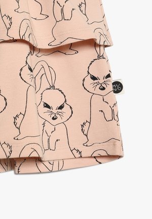 Jasnoróżowa tkanina z czarnymi obrysami zagniewanych króliczków oraz małą czarno-białą metką marki odzieżowej.