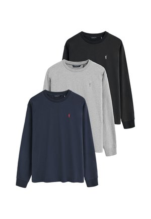 Tre magliette a maniche lunghe con scollo rotondo in nero, grigio e blu navy, ciascuna con un piccolo logo ricamato sul petto sinistro.