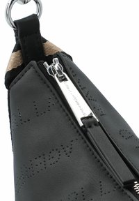 Schwarze Lederhandtasche mit strukturiertem Finish, metallic Reißverschluss und einem Stoffträger mit einem tan- und schwarzfarbenen Muster.