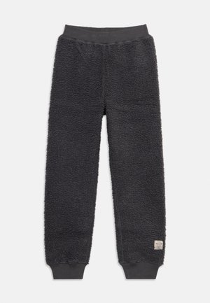 Sorte fleece joggebukser med elastisk linning og manchetter, med et lille rektangulært mærke nær den nederste kant på det ene ben.
