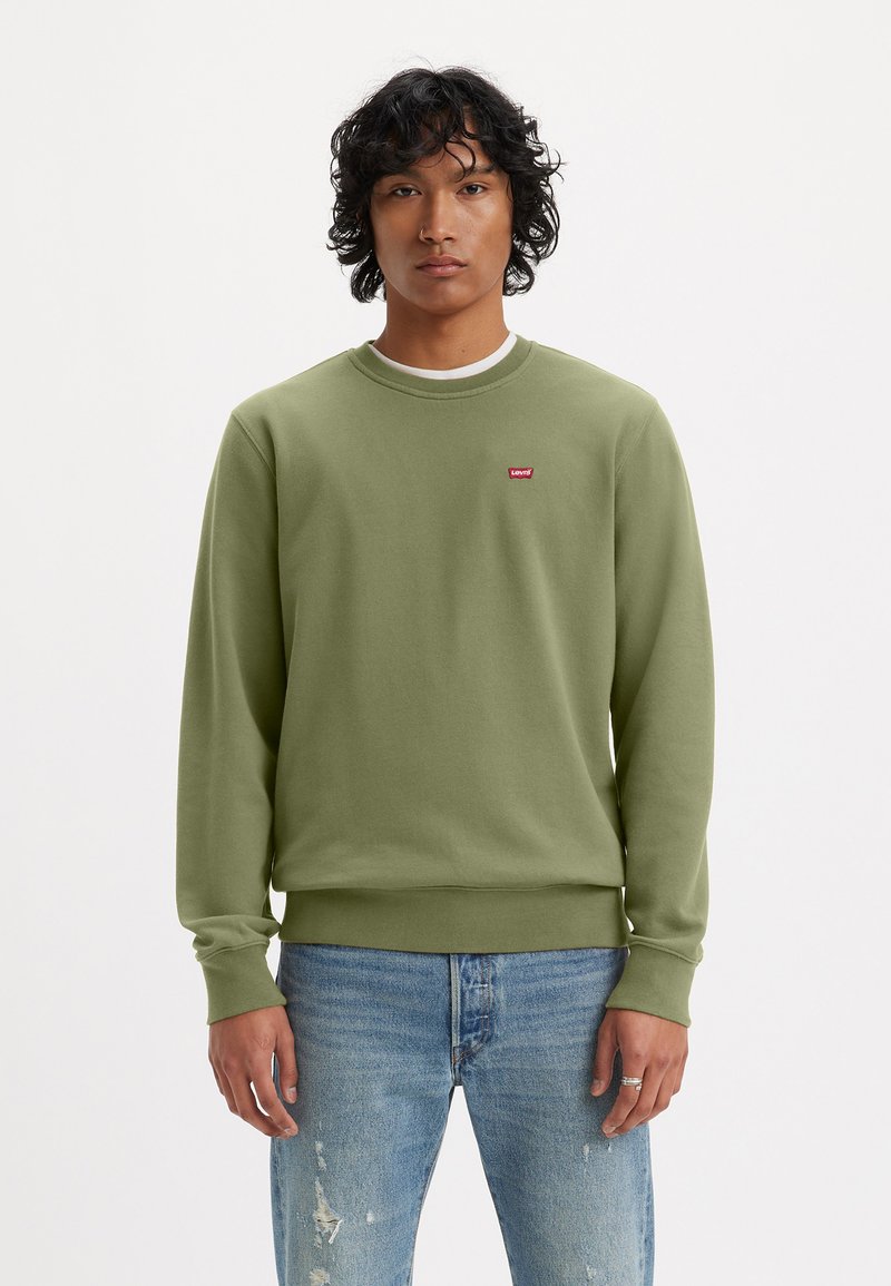 Groene sweatshirt met ronde hals en ribgebreide manchetten, voorzien van een klein rood Levi's-logo op de borst. Draag het met versleten blauwe jeans.