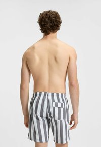 Zwemshorts voor mannen in grijs en witte verticale strepen. Elastische tailleband met verstelbaar trekkoord. Achterzak met flapdetail.