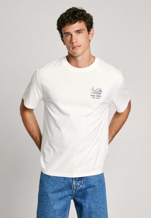 White cotton t-shirt with short sleeves, crew neck, and a blue graphic design featuring a fish. Paired with light blue denim jeans.
