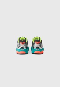 Pair of multicolor running shoes with neon yellow lining, teal midsoles, coral accents, and black mesh viewed from the back on white background.
