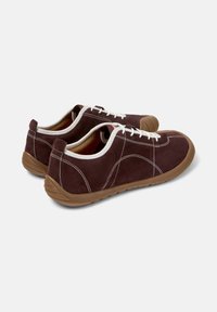 Brown suede shoes with white laces and stitching, featuring a tan rubber sole, displayed from an angled rear view on a plain background.