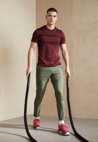 Under Armour UNSTOPPABLE - Spodnji deli trenirk - marine od green