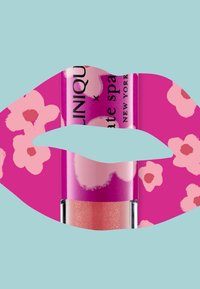 Glansende leppeprodukt i en klar tube, med et rosa blomsterdesign på en magentabakgrunn, og en myk ferskenfarget leppegloss inni.