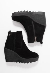Svarta mocka kilklackstövletter med en texturerad gummisula, dragkedja på sidan och en dragflik bak. Har släta och ribbade accenter.