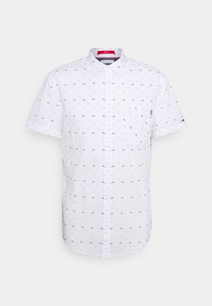 Chemise blanche à manches courtes boutonnée avec petits logos imprimés noirs et rouges, poche avant et col classique.