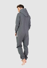 Grijze fleece onesie met een capuchon, lange mouwen en omgeslagen enkels. Beschikt over een voorkant zak en een ritssluiting aan de zijkant op de taille.