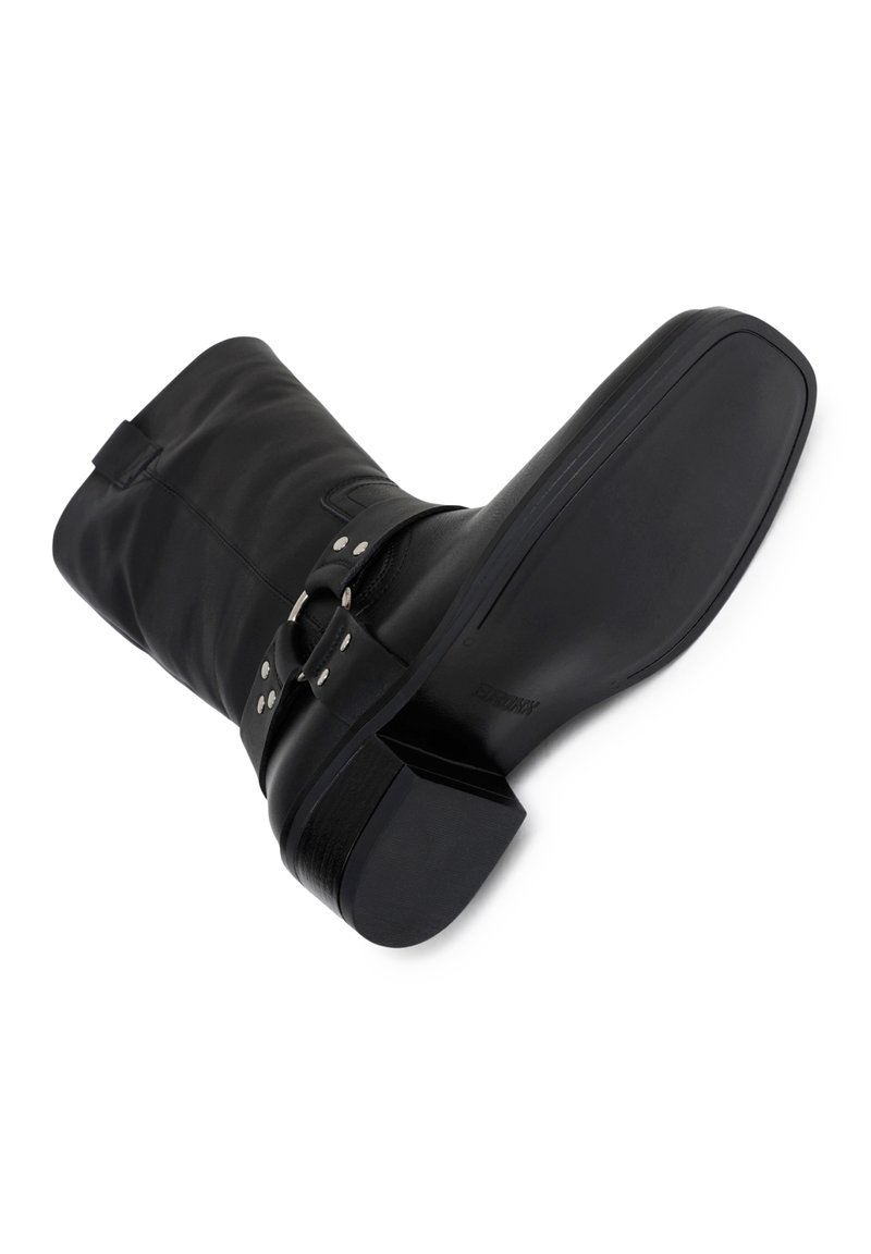 Czarne skórzane botki do połowy łydki z kwadratowym noskiem, niskim blokowym obcasem i detalem z klamrą wokół kostki na białym tle.