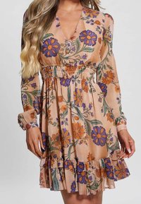 Vestido floral de tejido melocotón, con flores moradas y naranjas, mangas largas, dobladillo con volantes y cintura elástica para un ajuste relajado.