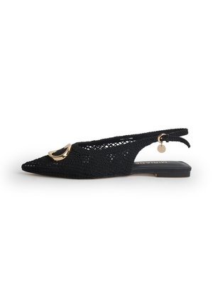 Scarpa bassa slingback nera a trama aperta con punta appuntita, fibbia decorativa color oro e piccolo ciondolo rotondo sul cinturino alla caviglia.