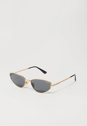 Occhiali da sole a forma di occhio di gatto con lenti grigie scure, montatura in metallo dorato e tempie nere affusolate. Branding sottile sulla lente.
