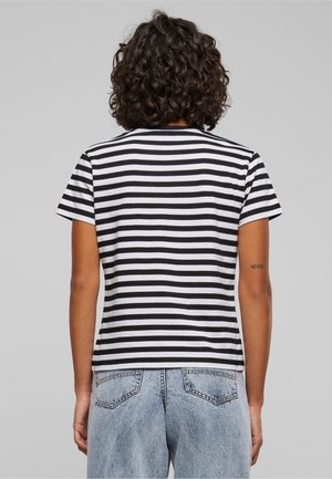 Black and white striped t-shirt with short sleeves and a crew neck, made from soft fabric, paired with light blue high-waisted jeans.