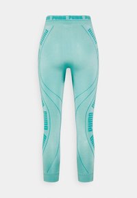 Leggings turchesi con branding PUMA lungo la vita e i lati, realizzati in morbido tessuto elasticizzato con una texture liscia.