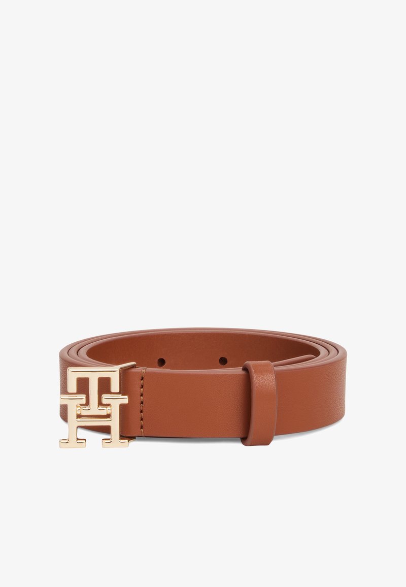 Ceinture en cuir marron clair roulée avec boucle double lettre "T" en or et passant, présentée sur fond blanc.