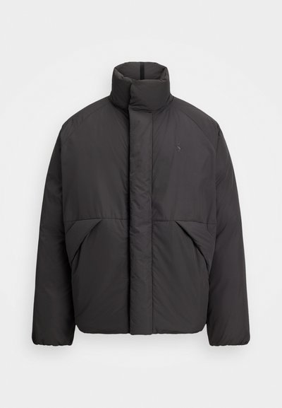 Mustat puhallettavat takki, jossa on korkea kaulus, piilotettu etuvetoketju, sivutaskut ja brodeerattu logo vasemmassa ylärinnassa.