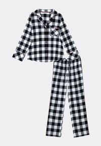 Pigiama a scacchi bianco e nero con una camicia con bottoni dotata di taschino e pantaloni lunghi con vita elastica, accentuati da piping rosso.