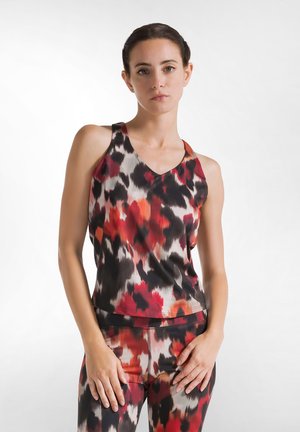 Zwarte, rode en witte abstracte print V-hals, mouwloze top; gladde stof; losse pasvorm; gecombineerd met bijpassende leggings met patroon.