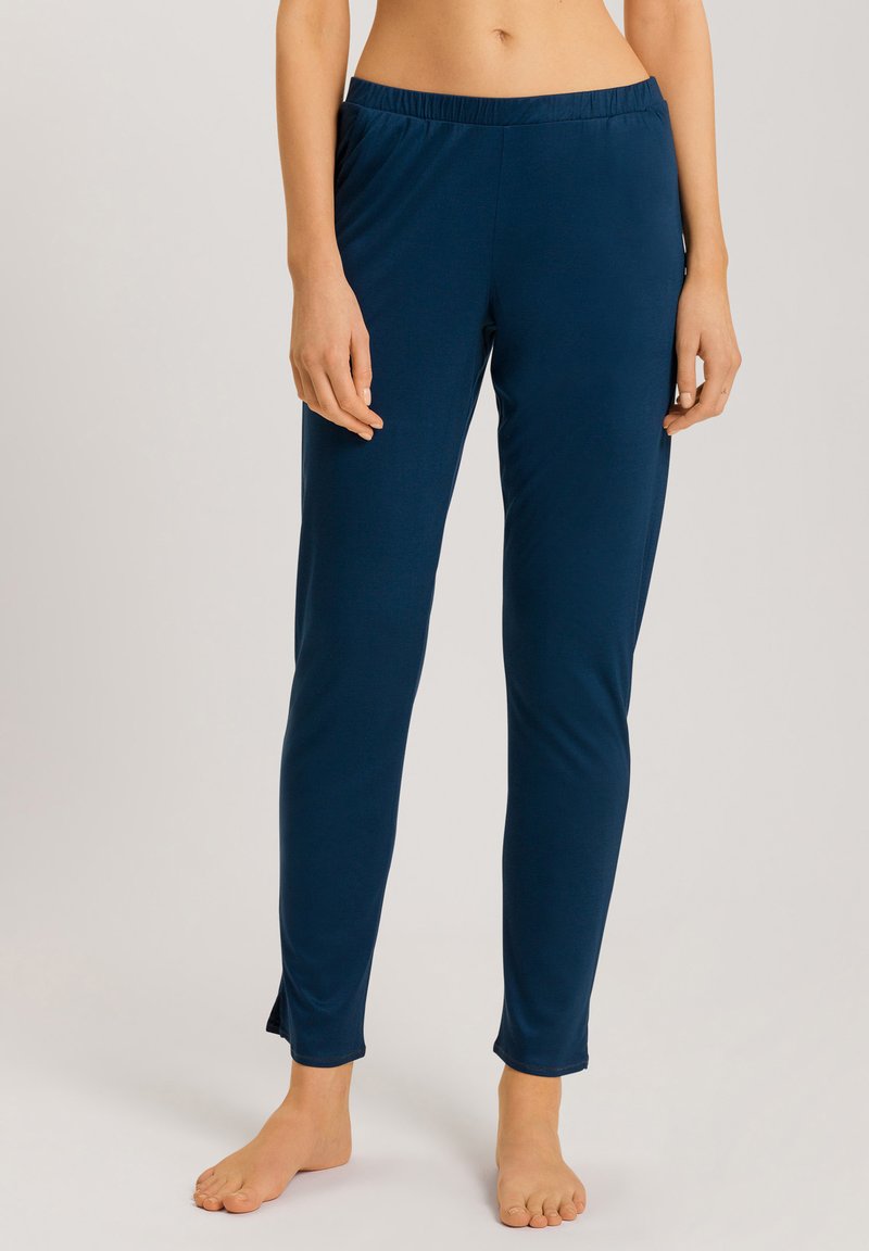 Pantalones de lounge ajustados en azul marino, hechos de una tela suave, con cintura elástica y dobladillo ligeramente acampanado; cuentan con aberturas en el tobillo.