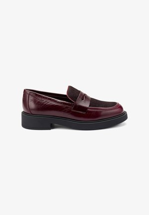 Mocassins en cuir bordeaux avec une tige noire texturée, bout rond et un petit talon noir. Présente des détails cousus et un accent de bride.