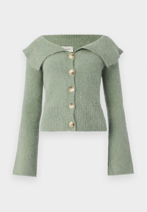 Vihreä olkapäiltä avonainen neuletakki, joka on valmistettu teksturoidusta neuloksesta, pitkähihaisella mallilla ja neljällä suurella beigeillä napilla edessä.