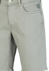 Shorts en denim gris clair avec un design classique à cinq poches, des détails de couture subtils et une coupe droite. Texture douce avec une élasticité modérée.