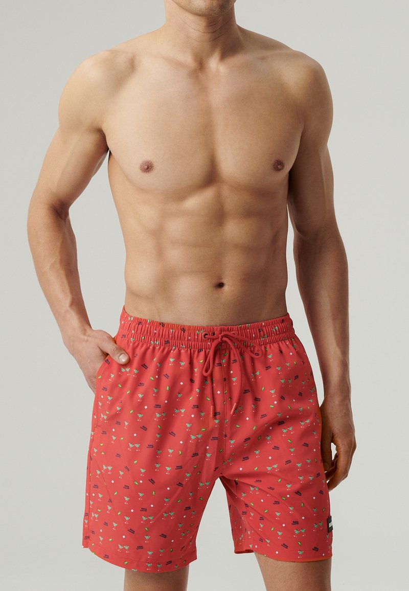 Czerwone kąpielówki z elastycznym pasem z sznurkiem, w jasny wzór składający się z różnych kolorowych kształtów oraz z boczną naszywką z logo. Wykonane z lekkiego materiału.