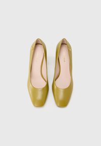 Zielone skórzane szpilki z kwadratowym noskiem i gładką fakturą. Wnętrze wyściełane jasnoróżową wkładką, z małym logo po boku.