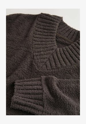 Mörkgrå tröja med texturerad ribbad krage och ärmar, i ett mjukt, plyschaktigt tyg som ser tjockt och mysigt ut.