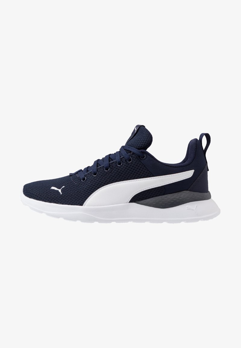 Chaussure de sport bleu marine avec des accents blancs et une tige en mesh. Elle dispose d'un col rembourré, d'une semelle en caoutchouc et d'un logo distinctif sur le côté.