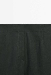 Dark green linen trousers with a smooth texture, featuring a flat waistband and subtle stitched detailing, no visible pockets.