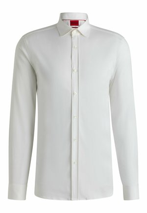 Vit långärmad skjorta i slät tyg, med klassisk krage, knäppning fram och knappar vid ärmsluten. Etikett synlig inuti.
