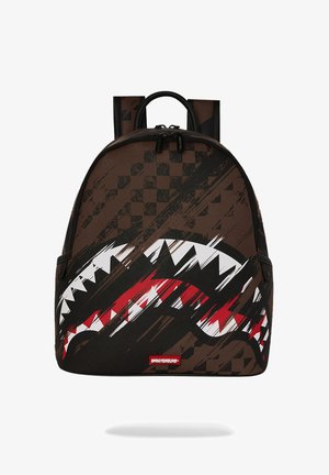 Mochila marrón con patrón de tablero de ajedrez negro y gráfico audaz de boca de tiburón en blanco, rojo y negro en el panel frontal.