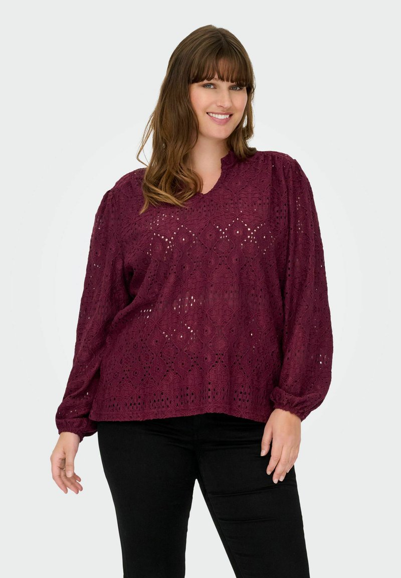 Bluzica v modri barvi Merlot z zapletenimi lasersko izrezanimi vzorci, naborki na rokavih in sproščenim krojem. Izdelana iz lahkotnega, strukturiranega materiala.